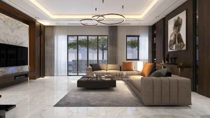 Bố trí nội thất phòng khách biệt thự cao cấp với gam màu nâu chủ đạo từ gỗ ốp tường, kệ trang trí, bàn trang trí. Thiết kế nội thất
